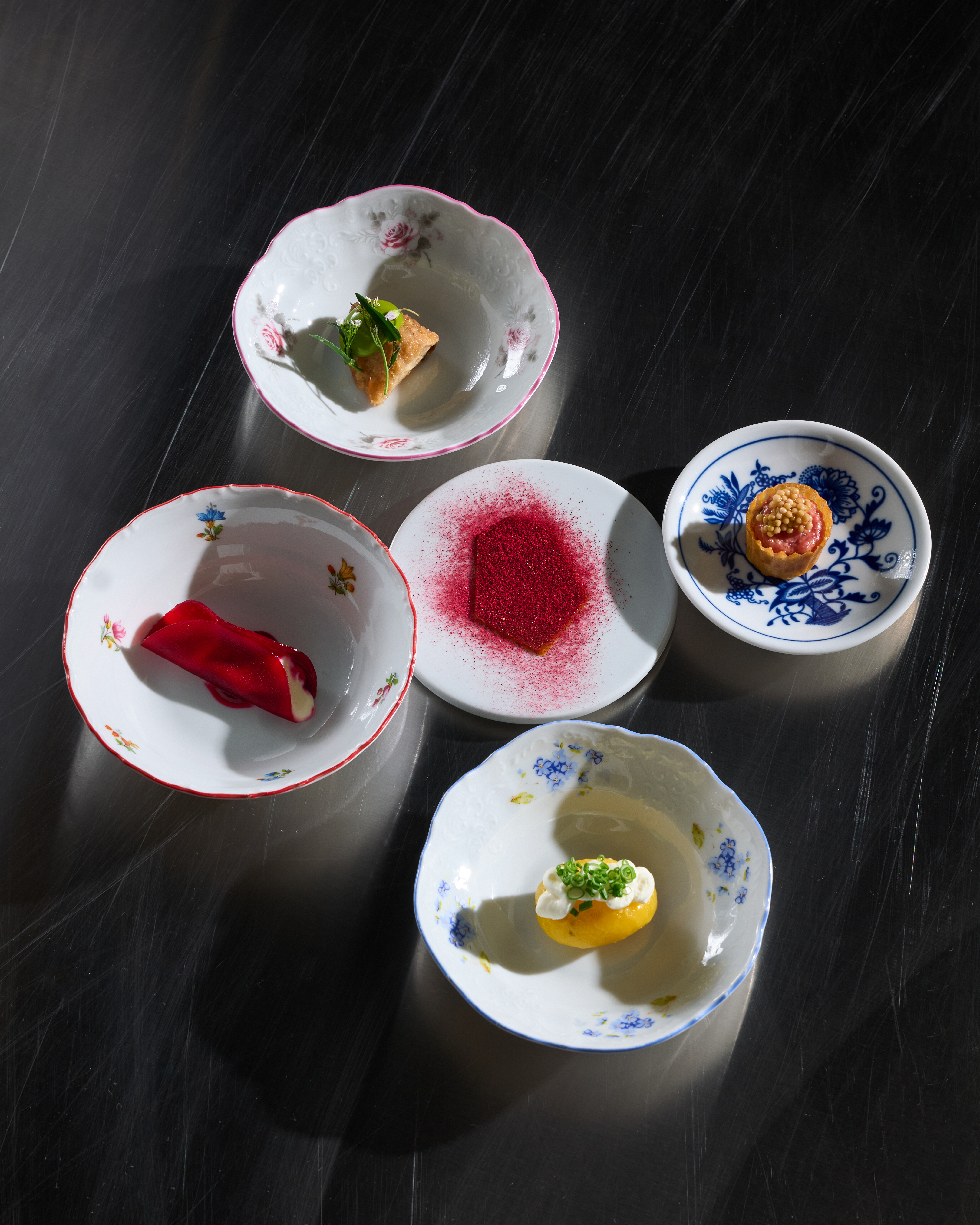 Five small courses served on assorted porcelain dishes.